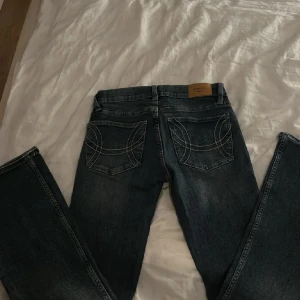 Gina jeans - Snygga mörkblå jeans från Acne Studios med raka ben och coola vita kontrastsömmar på bakfickorna. Klassisk femficksmodell och läderpatch i midjan. Perfekta för dig som gillar stilrena men unika detaljer.