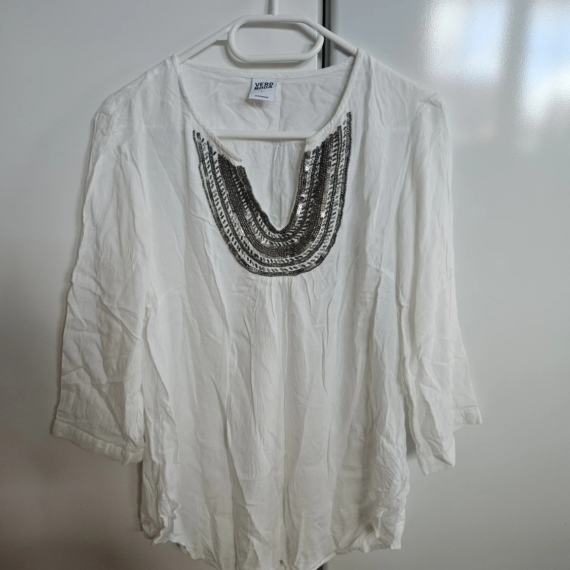 Vit blus med paljettdekor från vero moda