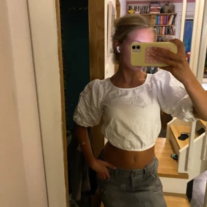 Vit croppad blus med puffärmar - Säljer en vit croppad blus med bred resår i midjan och stora puffärmar. Skitsnygg, passar till mycket men bland annat lite baggy lågmidjade jeans!🌊💕Tror att den var från hm.