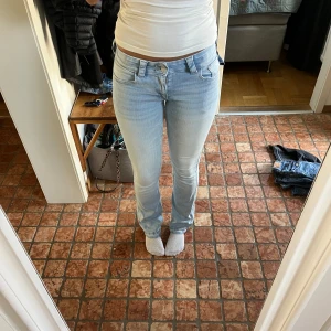 Bootcut ljusblå jeans från H&M - Säljer ett par ljusblå bootcut jeans från H&M med låg midja och justerbar midja. Jeansen har klassiska fickor fram och bak med snygga knappar på bakfickorna. Är i storlek 170, men passar mig som vanligtvis bär 27/36. Jag är 170💕