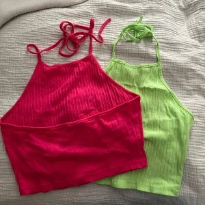 Ribbad rosa och grön linnetopp - Två  ribbade linnetoppar i stark rosa och neongrön färg. Båda har tunna axelband som knyts i nacken med öppen rygg och är tillverkade i mjukt material. Perfekta fest outfit😍 säljer båda tillsammans för 90kr, går även att köpa separat 50kr/st 💞