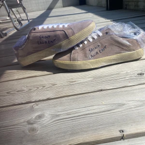 Saint Laurent mocka sneakers - Säljer dessa feta saint laurent skor som är inprincip oanvända skick 9/10 lite smuts på sulan men de kan man ta bort. Storlek 41. Bara skorna ingår. Pris 3500 kan diskuteras. Färgen är ljusbrun/beach. Byten funkar också 