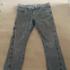 Blå raka jeans med broderade bakfickor - Flared jeans med detaljer på baksidan .