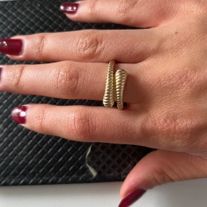 Guldig ribbad statementring - Cool ring i guldton med ribbad, snurrad design som ger en chunky och unik look. Perfekt för dig som vill sticka ut med accessoarerna och addera lite edge till din outfit. Säljs pga för stor