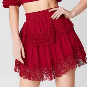 Röd volangkjol Linn Ahlborg x NA-KD - Röd kortkjol från Linn Ahlborg x NA-KD med bred resår i midjan och flera lager volanger. Kjolen har fina virkade spetsdetaljer och en luftig känsla. Passar dig som gillar färg och detaljer!