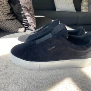 Svarta sneakers från Axel Arigato - Stilrena svarta sneakers från Axel Arigato i mocka med vit platt sula. 