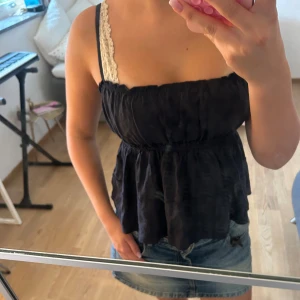 Mörkblå topp med volang - Säljer en mörkblå topp med smala axelband och volang nedtill. Toppen har en luftig passform. Perfekt för varma dagar! 💘