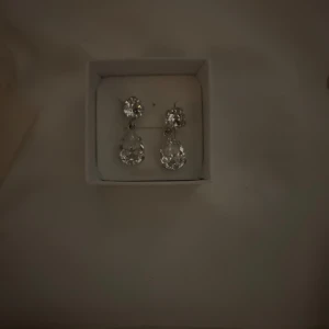 caroline svedbom örhängen silver - Orginalpris : 895kr, använda fåtal gånger! Säljer caroline svedbom örhängen med stora, droppformade stenar i silverfärg 