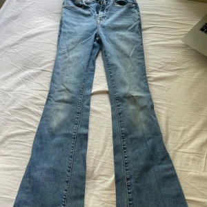 Levi's 726 Flare ljusblå jeans, W25 - Säljer ett par Levi's 726 Flare / bootcut jeans i ljusblå tvätt. Klassisk femficksmodell med flare-ben och snygga detaljer som bruna sömmar och läderpatch bak. 