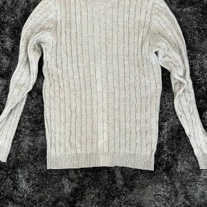 Ljusgrå kabelstickad tröja Alan Paine - Säljer en snygg ljusgrå kabelstickad tröja från Alan Paine i lyxig bomull. Tröjan är i mycket bra skick.
