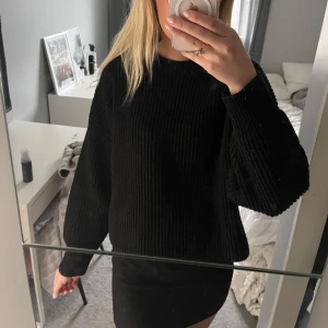 Svart stickad tröja - Säljer en svart ribbstickad tröja med rund hals och långa ärmar. Tröjan har en loose fit och är perfekt för dig som gillar en enkel men snygg stil. Passar till allt och är superbekväm att bära under kyligare dagar.
