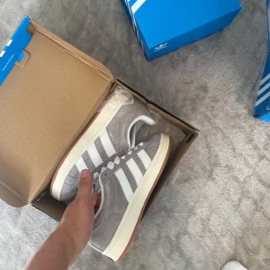 Adidas campus - 𝗔𝗱𝗶𝗱𝗮𝘀 𝗖𝗮𝗺𝗽𝘂𝘀 00 – 𝗴𝗿å, 𝘀𝘁𝗿𝗹 38 Helt nya och oanvända sneakers. Boxen är delvis skadad då de köpts upp från ett lager, därför säljs de billigare. Skorna är i perfekt skick.