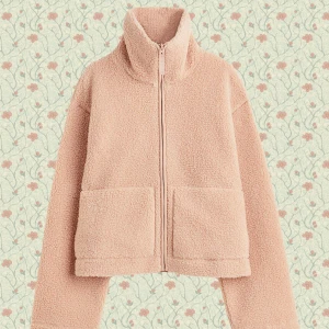 rosa teddyjacka - Mysig beige teddyjacka med hög krage och två stora fickor framtill. Jackan har en rak, lite boxig passform och stängs med dragkedja. Perfekt för kyliga dagar när du vill vara både varm och snygg.