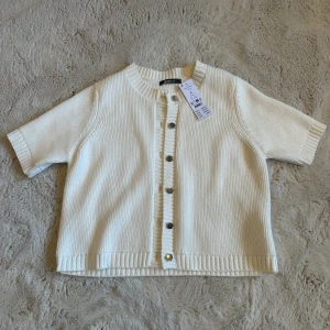 Vit kofta - Så snygg kortärmad, ribbstickad kofta i vit färg från Gina Tricot, aldrig använd och prislappen är kvar. Perfekt för lager-på-lager och enkel att styla till olika looks 💞