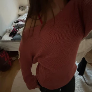 Rosa stickad tröja från Hunkydory - Säljer en rosa stickad tröja från Hunkydory med bred offshoulder-ringning och lång ärm. Tröjan har en loose passform och ett snyggt märke på ena ärmen. Perfekt för dig som gillar avslappnad och trendig stil. Storlek M men kan passa S💞