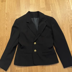 Kavaj - Svart kavaj i gulddetaljer storlek M helt ny 