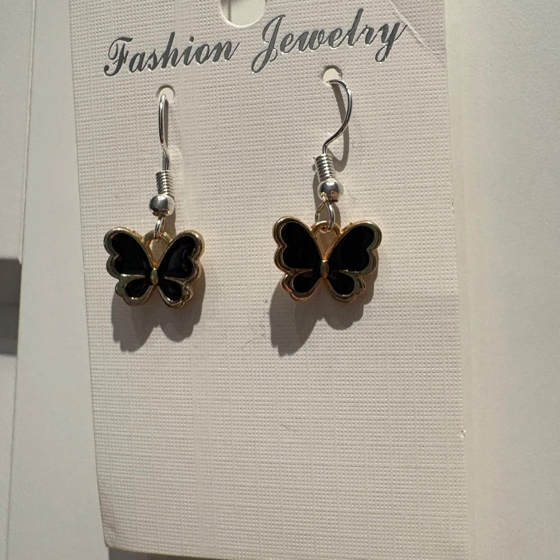 Svarta fjärilsörhängen med guldkant