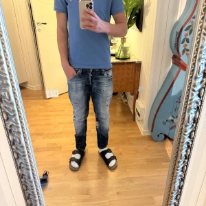 Jack & Jones blå slim fit jeans - Säljer ett par snygga blå slim fit jeans från Jack & Jones i storlek 30/32.  De skulle passa dig som är runt 165-175cm lång. Jeansen har slitna detaljer, ljus tvätt och klassisk femficksdesign. Perfekta för dig som gillar en smal passform och streetig look.
