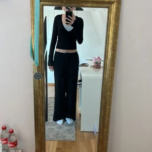 Svart v-ringad långärmad topp Gina Tricot - Säljer en svart långärmad topp från Gina Tricot med snygg v-ringning och figurnära passform. Perfekt att styla med jeans eller kjol. Materialet är mjukt och stretchigt, vilket gör den bekväm att bära hela dagen. Som ny, bara använd några gånger 💕