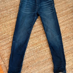 Mörkblå skinny jeans Jack & Jones - Snygga mörkblå skinny jeans från Jack & Jones med coola slitningar och tvättade detaljer. Klassisk femficksmodell och stretchigt jeanstyg som sitter tajt hela vägen ner. Perfekta för dig som gillar en smal siluett och stilren look.