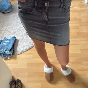 Grå jeanskjol med rå kant - Säljer en grå jeanskjol med snygg  kant nedtill och klassiska fickor både fram och bak. 