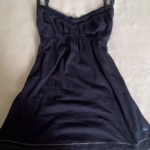 Abercrombie babydoll topp - Säljer en abercrombie & fitch babydoll topp i stl M i marinblå, fina detaljer på axelbanden och bysten.! Vintage och rare. Är öppen för prisförslag!❣️🍒 fläck på sidan men går säkert bort i tvätten