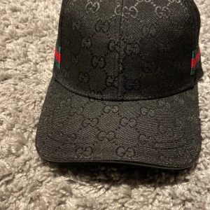 Svart Gucci keps  - Svarta Gucci keps passar allt och alla eftersom storleken är anpassbar på baksidan, skickar samma dag som köp!
