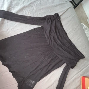 Svart offshoulder topp från BikBok - Svart offshoulder topp från BikBok i storlek L. Toppen har långa ärmar och en bred volang över axlarna som ger en snygg och trendig look. Perfekt att styla med jeans eller kjol för en cool outfit.