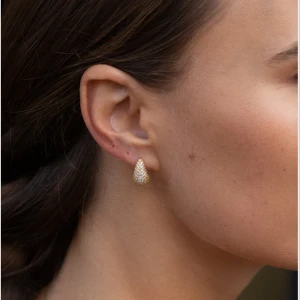 Glittriga droppformade örhängen i guld - Snygga droppformade örhängen i guldton med massor av små gnistrande stenar som ger en riktigt lyxig känsla. Perfekta för att lyfta vilken outfit som helst och ger ett elegant intryck. Lätta att bära och passar dig som gillar att sticka ut.