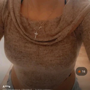 Beige croppad offshoulder topp - Trendig croppad topp i beige med offshoulder-design och långa ärmar. Toppens material är mjukt och stretchigt, perfekt för en chill och snygg look. Den har en bred krage som vilar snyggt över axlarna och ger en avslappnad vibe.