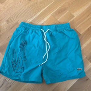 Gröna Lacoste badshorts  - Lacoste badshorts gröna storlek L passar M