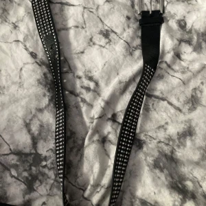 Svart bälte med silvernitar - 90cm