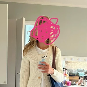 Beige stickad kofta med knappar - Snygg beige stickad kofta med v-ringning och knappar framtill. Perfekt att slänga över en t-shirt för en chill och stilren look. Koftan har lång ärm och en klassisk passform som funkar till det mesta.