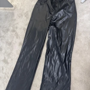 Svarta raka skinnbyxor - Snygga svarta byxor i skinnimitation med raka ben. Är helt nya, säljer då jag beställde fel storlek. Priset kan diskuteras. Byxorna passar både Xs och S. Skriv privat om ni vill ha fler bilder