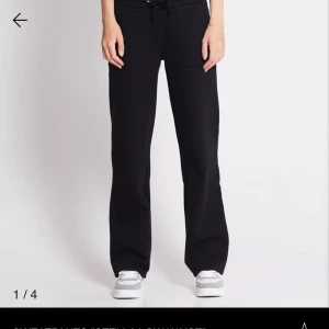 Svarta mjukisbyxor med snörning - Svarta mjukisbyxor med breda ben och snörning i midjan. De har stora fickor fram och bak, samt en avslappnad passform som ger en chill vibe. Perfekta för att hänga hemma eller dra till gymmet. Materialet är väldigt mjukt och bekvämt. Pris kan diskuteras.