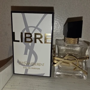 Yves Saint Laurent Libre Eau de Parfum - Snygg och lyxig parfym från Yves Saint Laurent, Libre Eau de Parfum. Flaskan är transparent med gulddetaljer och har en svart fyrkantig kork med guldfärgat halsband. Förpackningen är vit med guldtext och YSL-logga. Innehåller 30 ml.