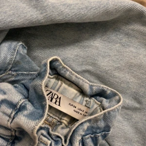 Ljusblå jeans med resårmidja från Zara - Säljer ett par ljusblå jeans från Zara med resår i midjan och klassisk knappstängning. Jeansen har raka ben och är tillverkade i mjukt bomullsjeans. Perfekta för en chill och avslappnad look.