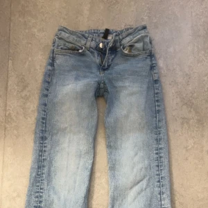 Ljusblå raka jeans med slitning - Säljer ett par ljusblå jeans med raka ben och snyggt slitna detaljer. Jeansen har klassisk femficksdesign och normal midja. Perfekta för en avslappnad och trendig look.