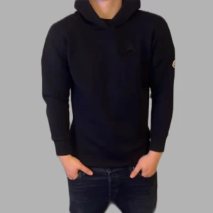 Svart hoodie från Moncler - Säljer en stilren svart hoodie från Moncler med deras ikoniska logga på ärmen. Tröjan har en klassisk passform med långa ärmar och en bekväm luva. Skick 10/10 nästintill ny och är köpt på NK