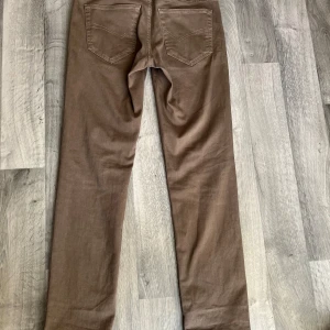 Bruna chinos från Altinyildiz Classics - Snygga bruna chinos från Altinyildiz Classics i storlek 46. Byxorna är raka i modellen med klassiska bakfickor och tillverkade i mjuk bomull med lite stretch. Perfekta för en clean och stilren look.