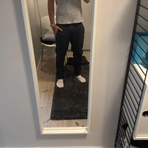 Mörkblå linnebyxor med resårmidja - Säljer ett par mörkblå linnebyxor med avslappnad passform och elastisk midja. Byxorna har sidfickor och är perfekta för en chill och stilren look. Lätta och sköna, passar grymt till både t-shirt och skjorta.