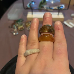 3 chunky ringar i resin - Tre chunky ringar i resin med coola former och marmorering. En är brun med marmorerat mönster, en är bärnstensfärgad och en är mjölkigt vit med vågig form. Perfekta för att ge din look en unik touch.