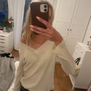 Beige v-ringad tröja från P.O.P - Supermjuk beige tröja från P.O.P med v-ringning och långa ärmar. Snygg ribbad kant vid halsringningen och ärmsluten. Super fin tröja i merinoull, endast använd några gånger, crème färgad,