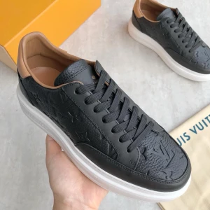 Louis Vuitton svarta sneakers i skinn - Snygga svarta Louis Vuitton sneakers i präglat skinn med klassiskt LV-mönster. Skorna har vita platta sulor, svarta snören och beige detaljer vid häl och insida. Perfekta för dig som vill ha en lyxig och stilren look med exklusiv känsla. Fler storlekar finns