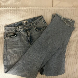 Ljusblåa wide jeans från Ginatricot  - Säljer ett par ljusblå jeans från Perfect Jeans i modell med raka, vida ben och råa, fransiga benslut. Klassisk femficksdesign och mid waist. Perfekta för en chill och trendig look.