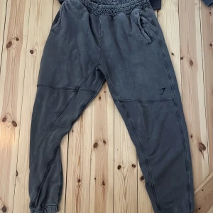 Gymshark oversize byxor+sweatshirt STORLEK L  - Säljer ett par mörkgrå oversize byxor+sweatshirt  från Gymshark. Nypris är 600kr för vardera. Knappt använda. Säljer dem som set för 700. Vill man ha dem separat är det 400kr  styck 