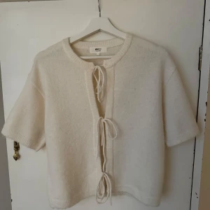 Vit kofta med knyt från Gina Tricot - Superfin vit kofta från Gina Tricot i ullblandning. Kortärmad modell med tre knyt framtill och ribbad kant vid halsen. Perfekt att slänga över en topp för en chill och trendig look! 💕Pris kan diskuteras ☺️