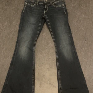 Bootcut jeans med broderade fickor Gina Tricot - Mörkblå bootcut jeans från Gina Tricot. Passar också som en S. Den har snygga kontrastsömmar och broderade bakfickor i gult och beige. Jeansen har klassisk femficksmodell och coola detaljer som ger en unik look. Perfekta för dig som gillar retrovibbar och statement-jeans.