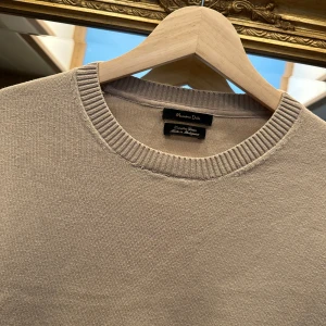 Beige stickad tröja Massimo Dutti - Snygg beige stickad tröja från Massimo Dutti med rund halsringning och ribbade muddar. Tröjan är i bomull och har en clean, klassisk look som funkar till allt. 