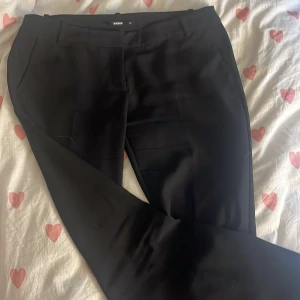 Svarta Vera Tall  kostymbyxor från BikBok - Snygga svarta kostymbyxor från BikBok i storlek 42. Byxorna har klassisk rak passform med diskreta fickor och midja som sitter bekvämt. Små i storlek passar mig som har M vanligtvist. Använda men fint skick!